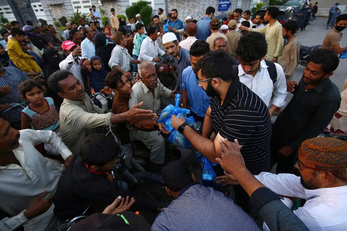 People get free food to break fast during the fasting month of Ramadan, in Karachi, Pakistan, on March 29, 2023. 