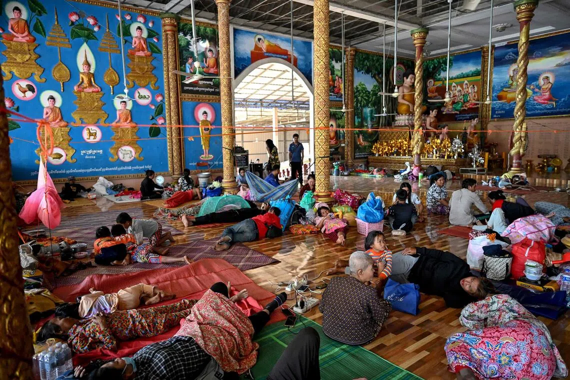 Cambodians rest inside a temple after they evacuated following clashes along the Cambodia-Thailand border, in Siem Reap, on Dec 9.