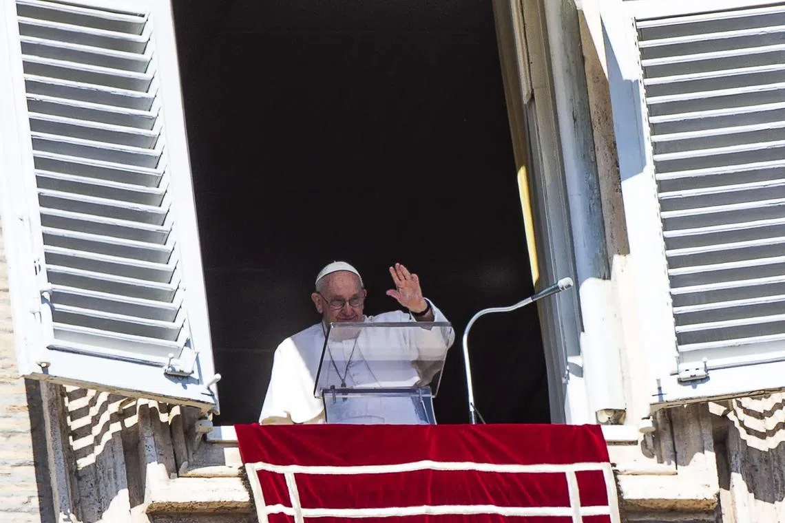 Pope Francis waves to faithful in St. Peter's Square as he leads the traditional Angelus Sunday prayer in the Vatican City. He called for an end to the deadly trafficking of migrants. 