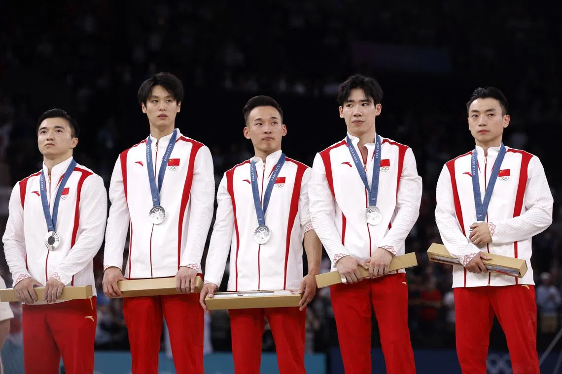 Paris 2024 Olympics - Artistic Gymnastics - Men's Team Victory Ceremony - Bercy Arena, Paris, France - July 29, 2024. Silver medallists Jingyuan Zou, Boheng Zhang, Ruoteng Xiao, Weide Su, and Yang Liu of China stand on the podium. REUTERS/Amanda Perobelli