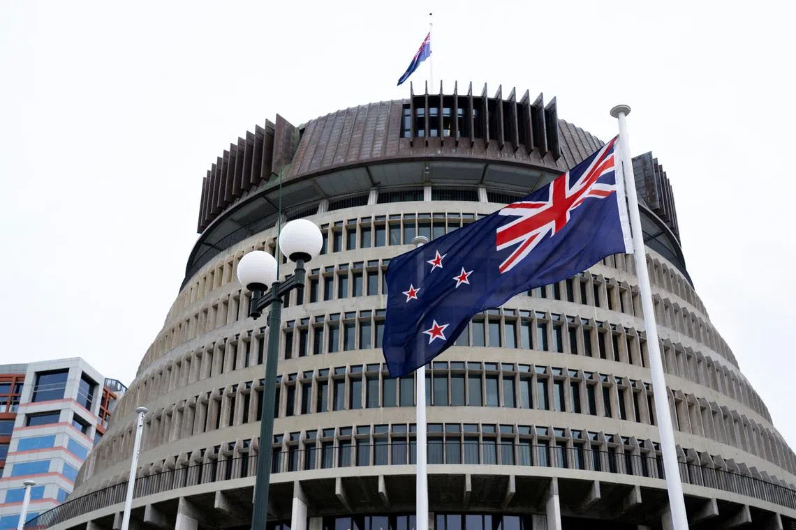 New Zealand's flag flutters in front of 'The Beehive', the executive wing of the New Zealand Parliament Buildings, in Wellington, New Zealand, September 24, 2025. REUTERS/Marty Melville
