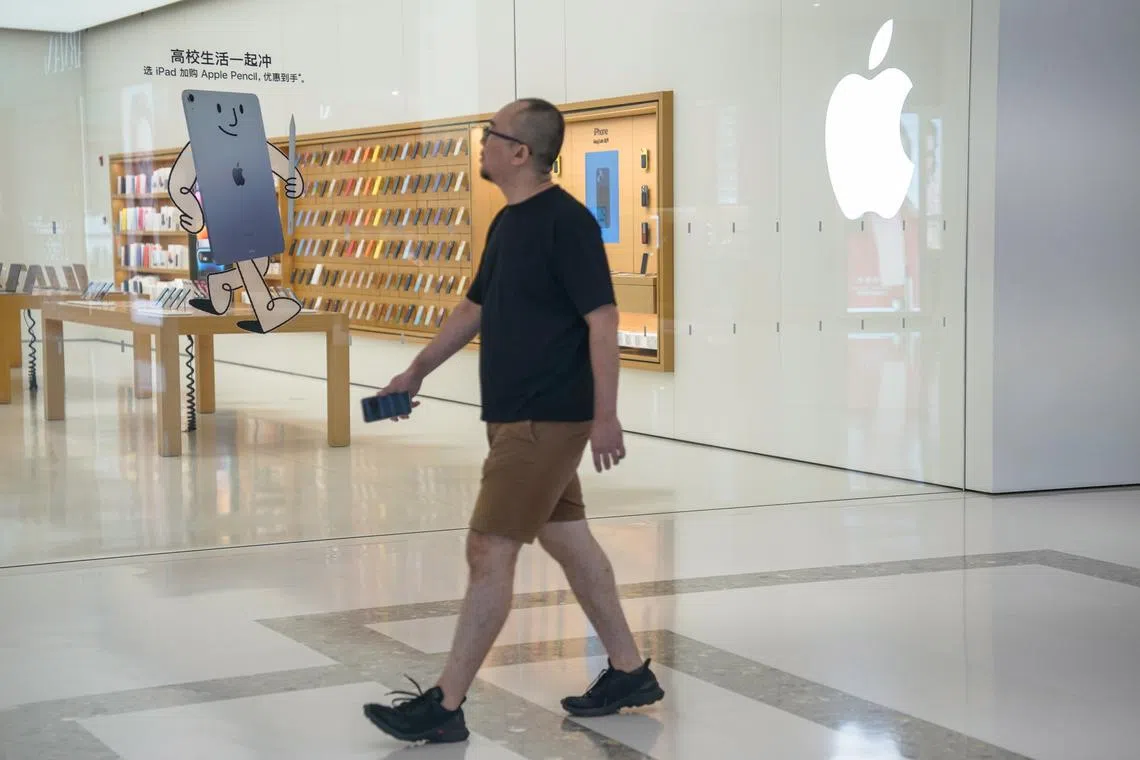 A man walks past an Apple store at a mall in Beijing, China.