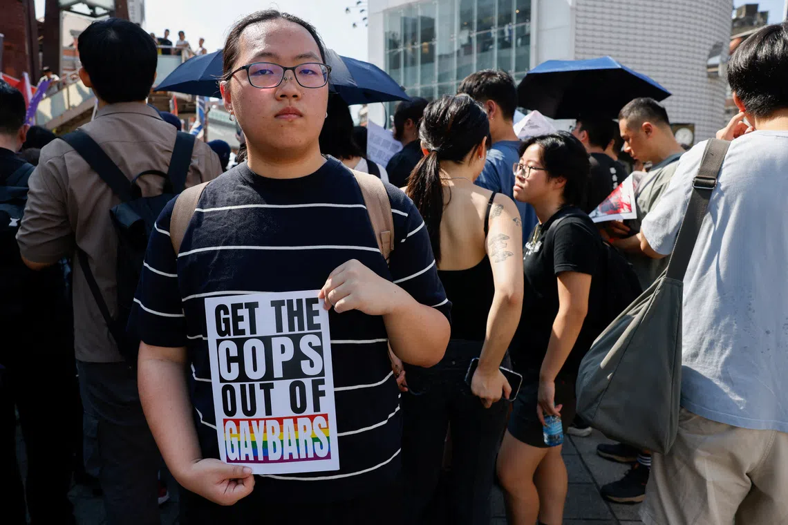 A protestor holding a sign as people march and protest after the police raided a gay bar ahead of the annual Taiwan Pride parade, in Taipei, on Oct 4.