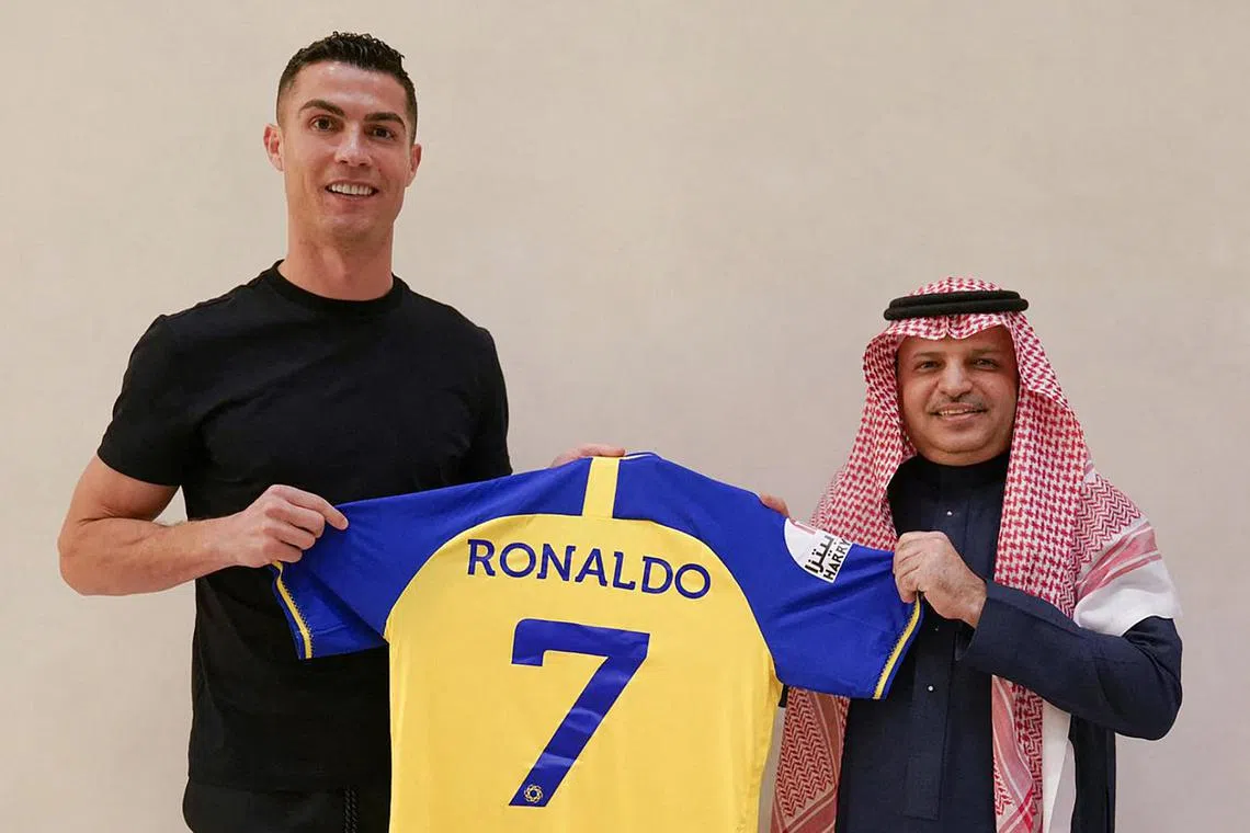 Cristiano Ronaldo being presented with Al Nassr's number seven jersey by club president Musalli Al-Muammar in Madrid, on Dec 30, 2022.