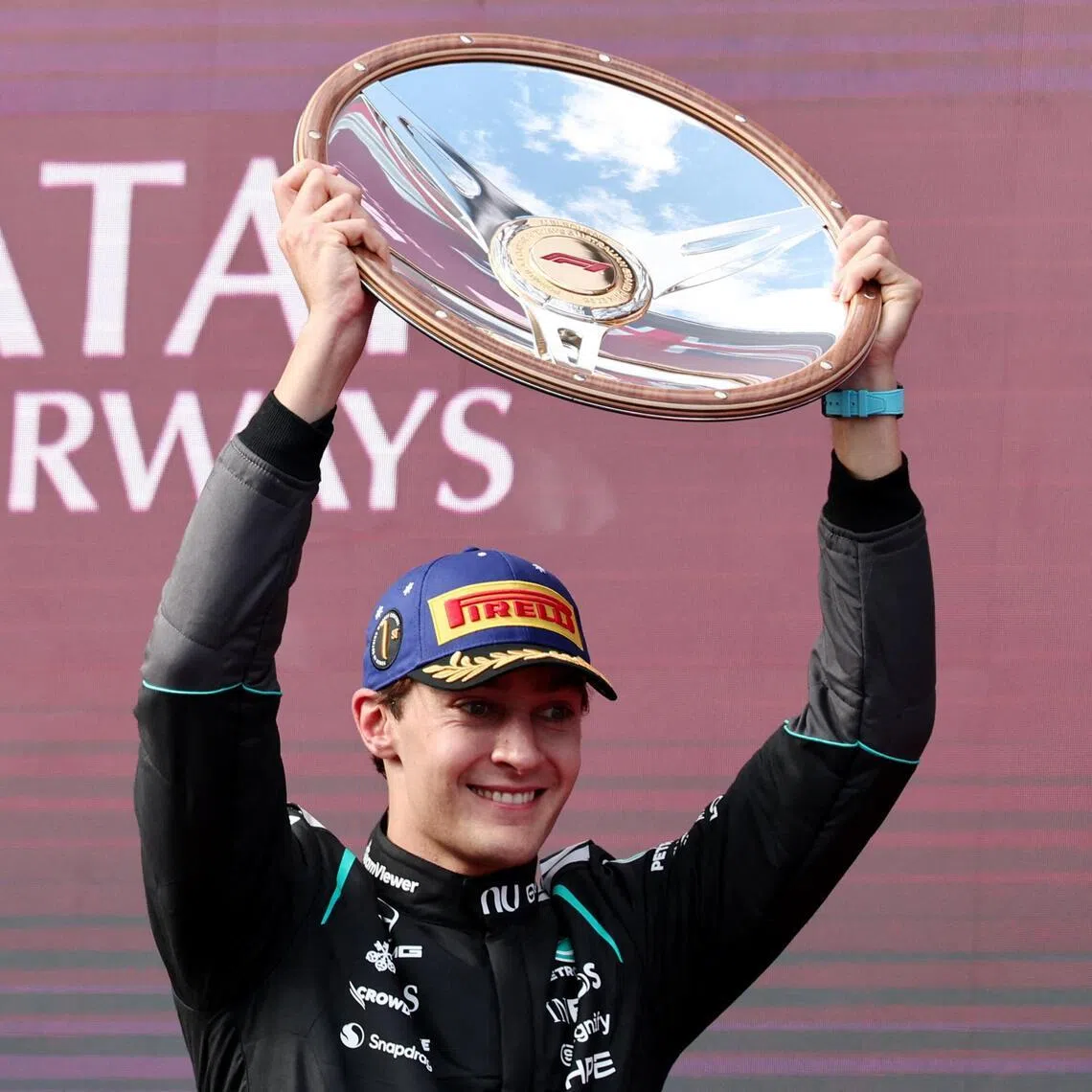 Mercedes' George Russell celebrates with the trophy on the podium after winning the Australian Grand Prix.