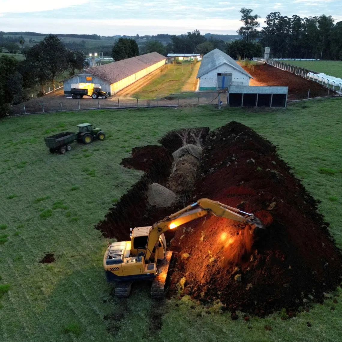 FILE PHOTO: An excavator moves earth next to a hole in the ground at a poultry farm after Brazil confirmed its first outbreak of bird flu on Friday, triggering protocols for a country-wide trade ban from top buyer China and state-wide restrictions for other major consumers, in Montenegro, Brazil May 16, 2025. REUTERS/Diego Vara/File Photo