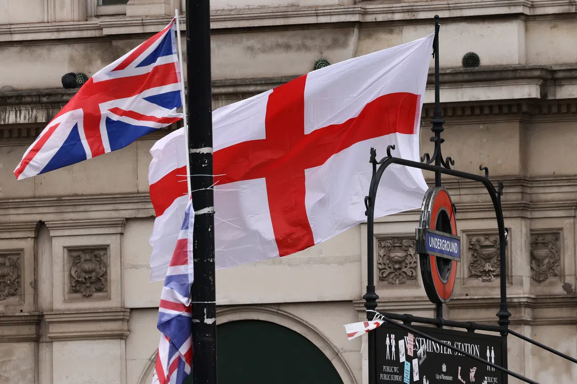 Union Jack and St George's Cross flags hang from a sign above Westminster underground station, the day after an anti-immigration rally organised by British anti-immigration activist Stephen Yaxley-Lennon, also known as Tommy Robinson, in London, Britain, September 14, 2025. REUTERS/Jack Taylor