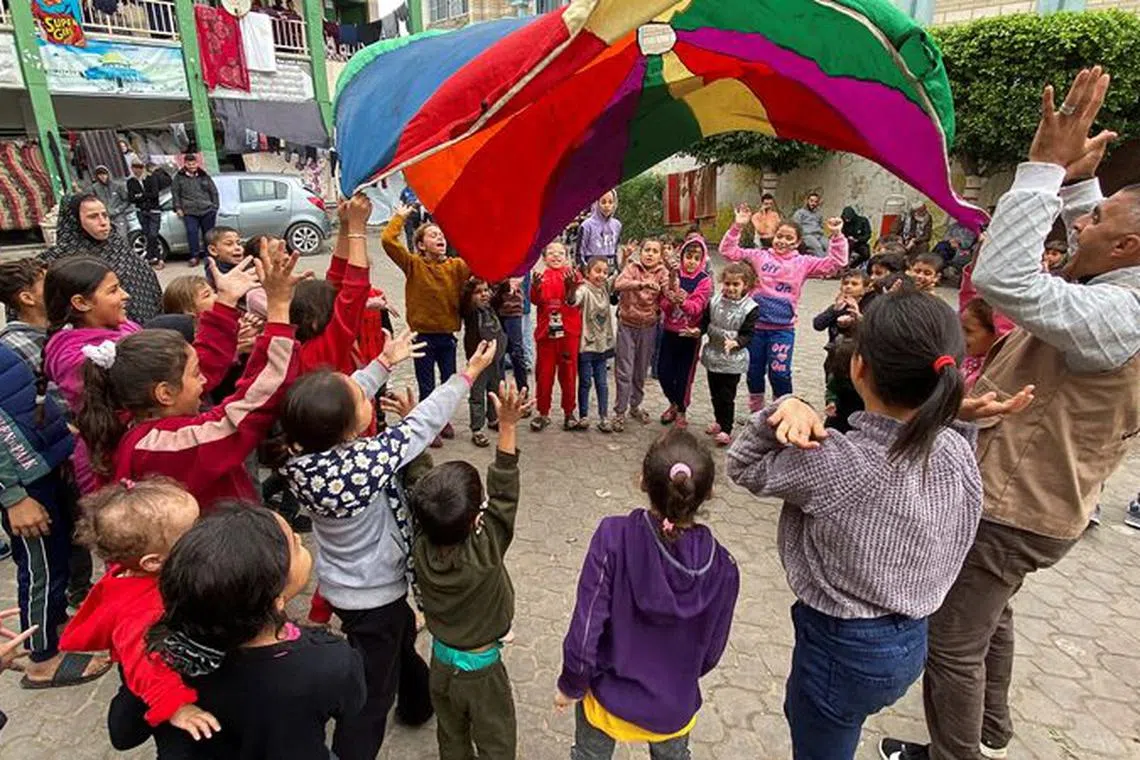 FILE PHOTO: Displaced Palestinians participate in activity organized by volunteers to entertain and support mental health of children affected by the conflict, during a temporary truce between Hamas and Israel, in Khan Younis, in the southern Gaza Strip, November 28, 2023. REUTERS/Arafat Barbakh/File Photo