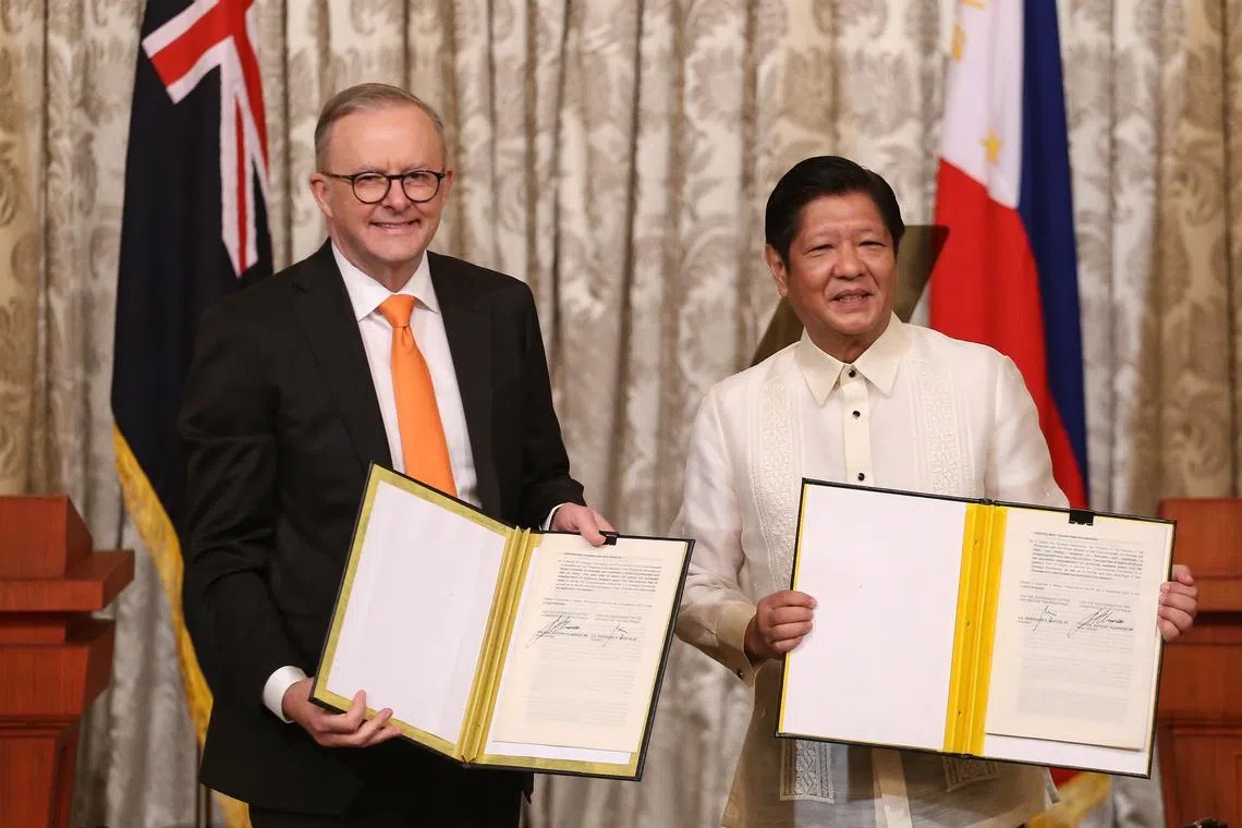 Australian Prime Minister Anthony Albanese (left) and Philippine President Ferdinand Marcos Jr. display signed documents.