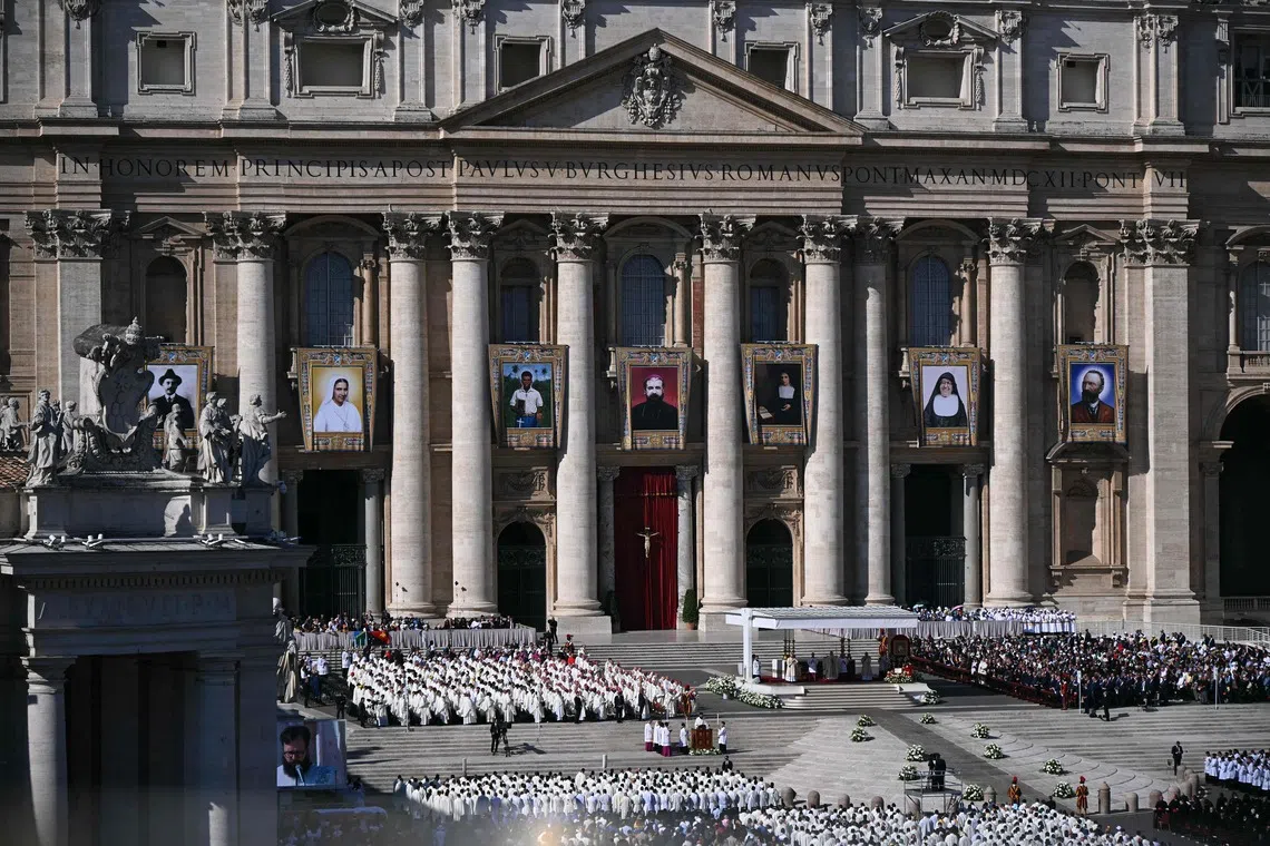 Portraits of the new saints are hung on St Peter's Basilica during a mass of canonisations in the Vatican on Oct 19.