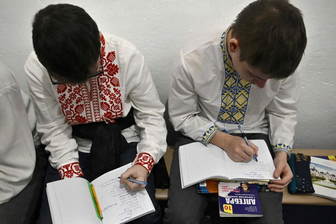 Children study in an air-raid shelter in the cellar of a school after an alarm signal in Kyiv on March 23.
