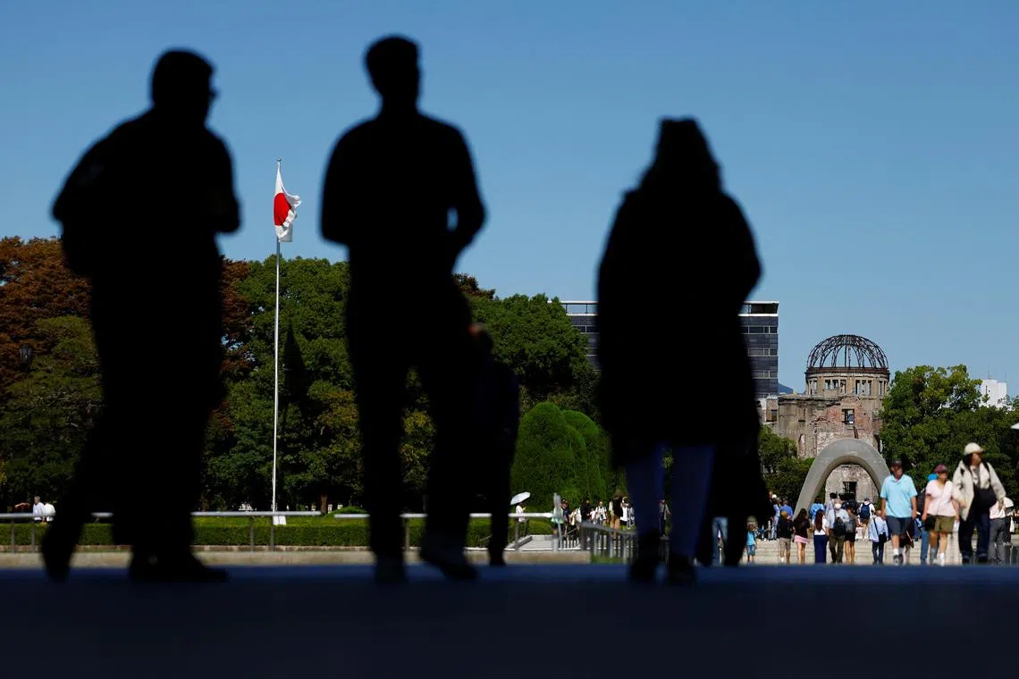 People visit the Cenotaph for the Victims of the Atomic Bomb and the preserved Atomic Bomb Dome at the Hiroshima Peace Memorial Park.