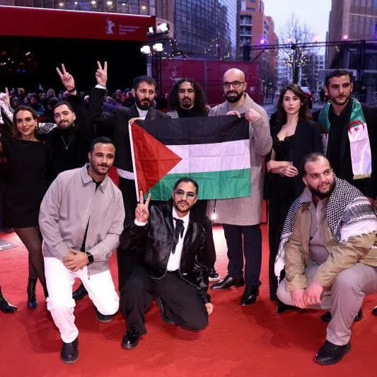 Crew of the film Chronicles from the Siege holds a Palestinian flag as they pose on the red carpet for the awards ceremony at the 76th Berlinale International Film Festival in Berlin, Germany, on Feb 21, 2026.
