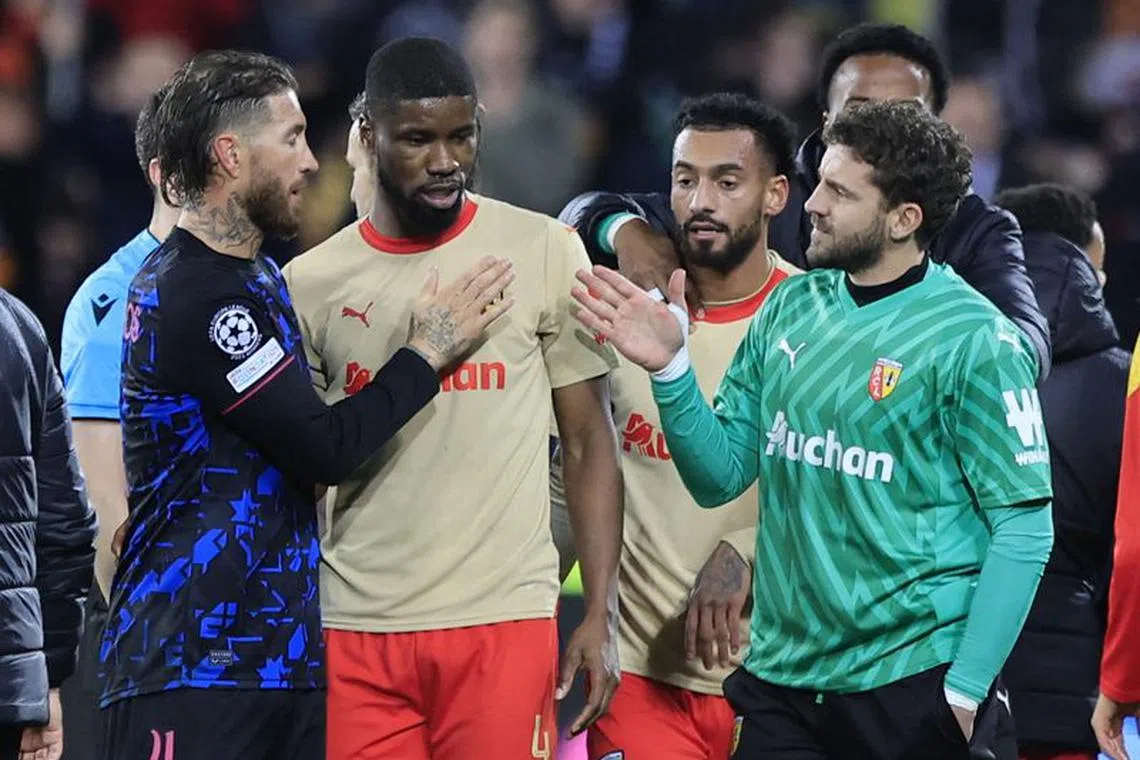 Soccer Football - Champions League - Group B - RC Lens v Sevilla - Stade Bollaert-Delelis, Lens, France - December 12, 2023 Sevilla's Sergio Ramos with RC Lens' Kevin Danso and teammates after the match REUTERS/Pascal Rossignol