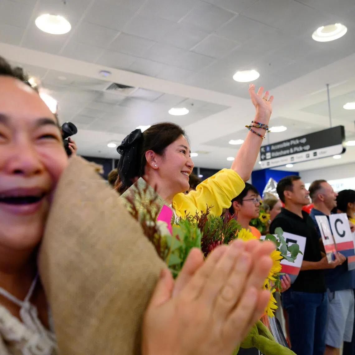 Friends and relatives welcome passengers on a flight from Dubai to Australia at Sydney International Airport on March 4 , 2026. 