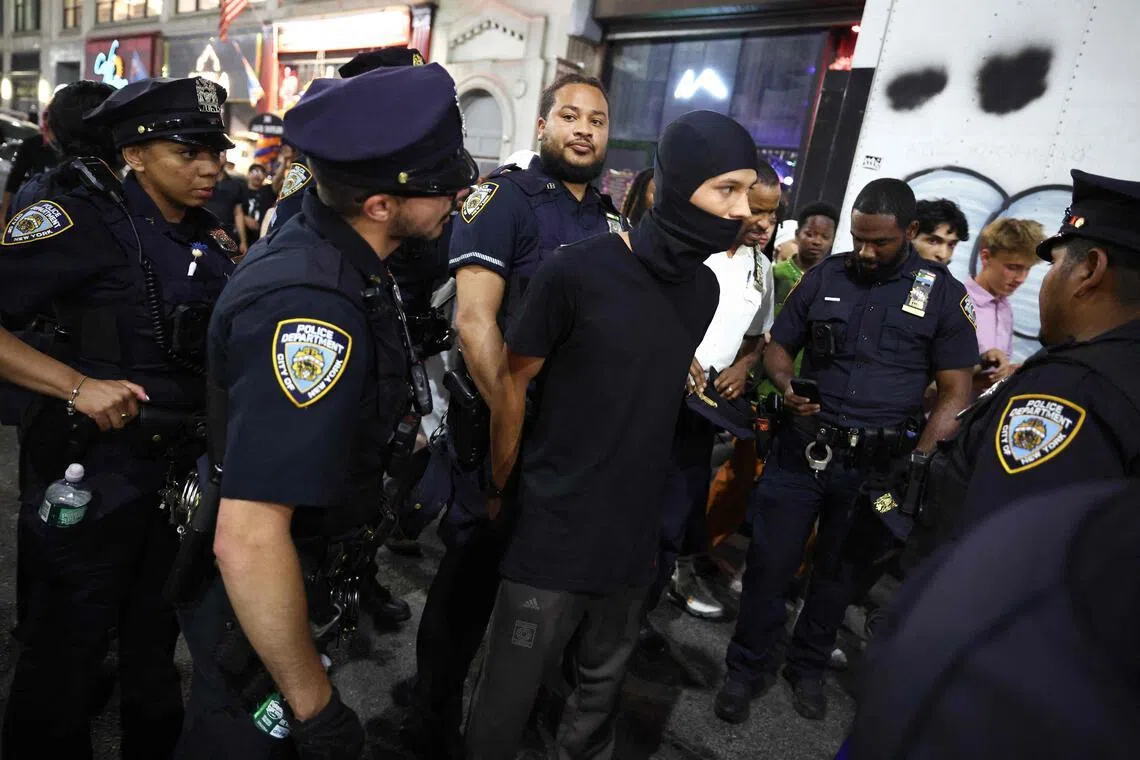 NYPD officers arrest a person as New York Knicks fans gather outside Madison Square Garden during Game 4 of the NBA Finals in New York on June 10.