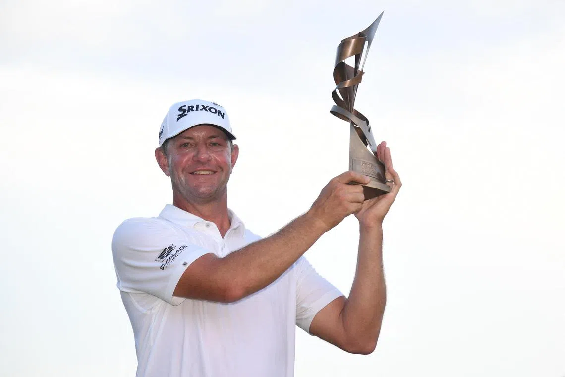 Lucas Glover posing for a photo with the championship trophy after winning a play-off hole against Patrick Cantlay during the final round of the FedEx St. Jude Championship.