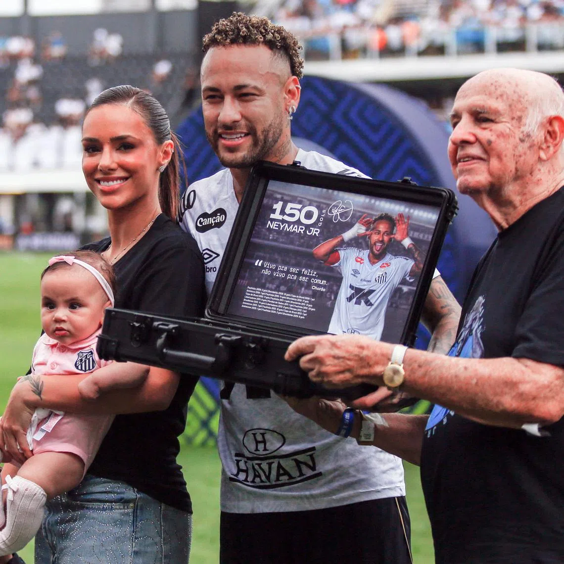 Soccer Football - Brasileiro Championship - Santos v Cruzeiro - Estadio Urbano Caldeira, Santos, Brazil - December 7, 2025 Santos' Neymar with his wife Bruna Biancardi and their daughters after receiving an award from former Santos player Pepe before the match REUTERS/Thiago Bernardes