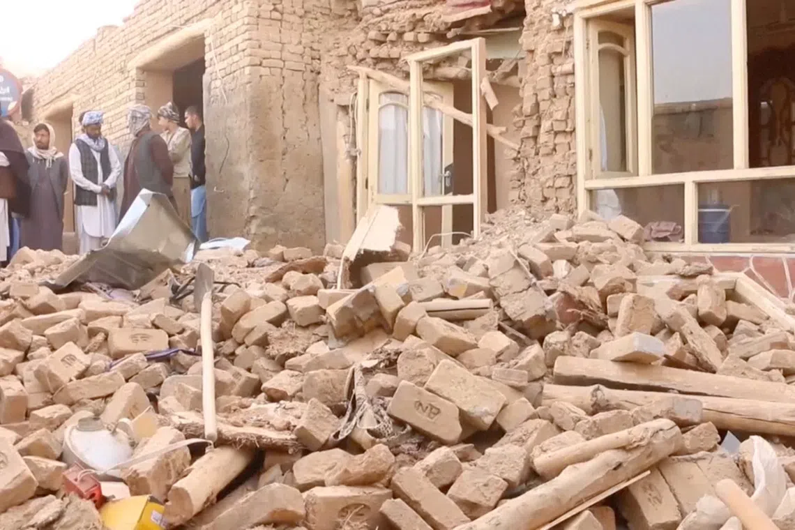People gather near a damaged building, in the aftermath of an earthquake, in Tashqurghan district, Samangan province, Afghanistan, November 3, 2025. Reuters TV/via REUTERS