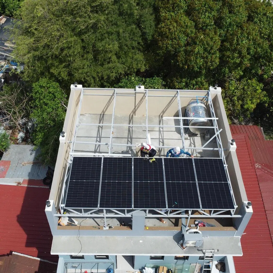 Workers install the solar panels at the home of journalism student Chris Josef de Jesus in Cavite, Philippines.