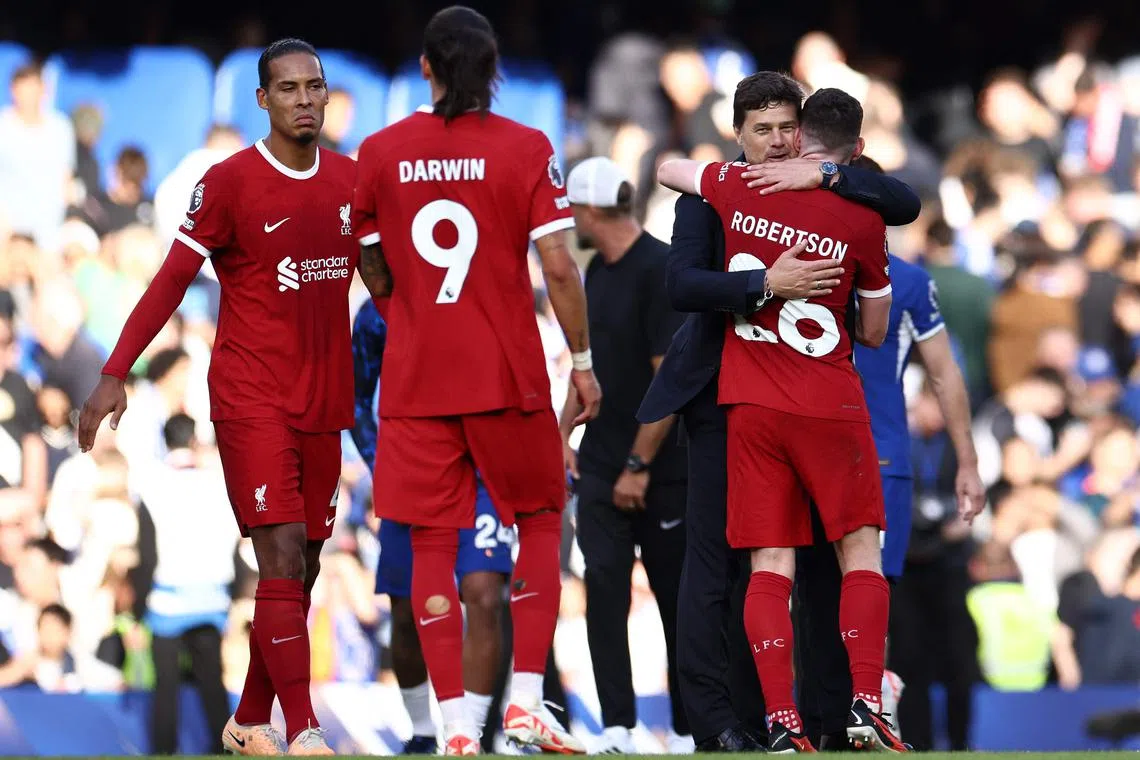 Chelsea's Argentinian head coach Mauricio Pochettino embraces Liverpool's Scottish defender Andrew Robertson.