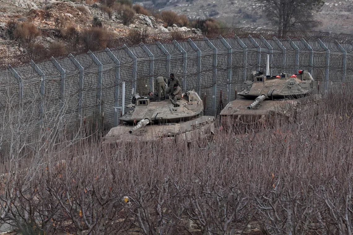 Israeli tanks at the security fence between Israel and Syria, near the Druze village of Majdal Shams, in the Israeli-annexed Golan Heights, on Dec 10.