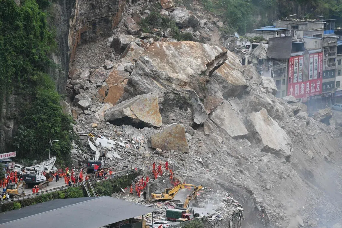 Rescue workers search for survivors at the site of a landslide in Pengshui County in Chongqing, China.