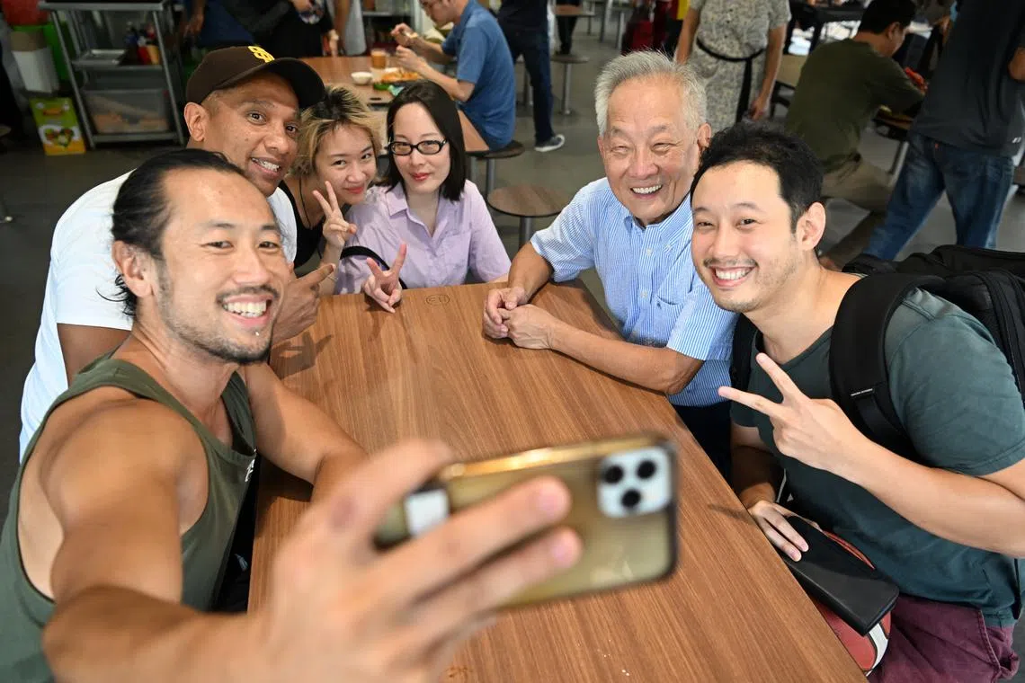 Presidential hopeful Ng Kok Song and his fiancee Sybil Lau (on his right) posing for a wefie with patrons at Seah Im Food Centre on Aug 13.