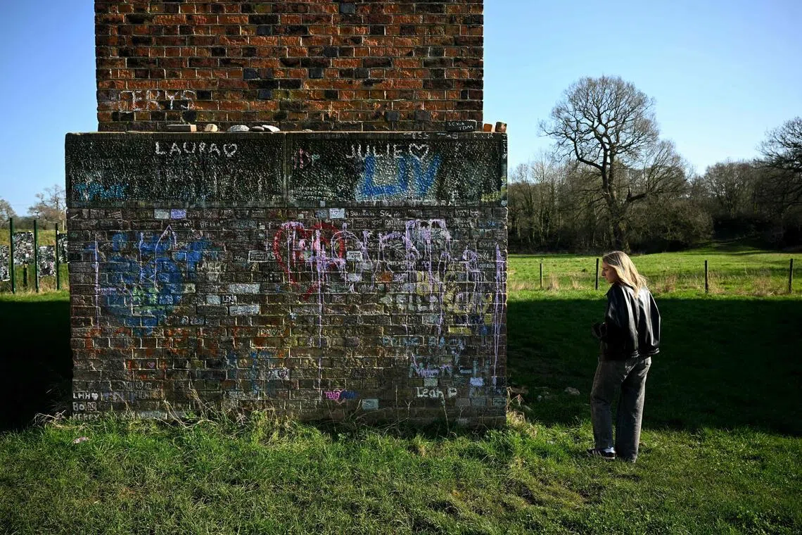 Former Harry Styles walking tour guide Chloe Thomason gestures to the names and messages written on the Twemlow Viaduct, in Holmes Chapel, north-west England, on March 4.