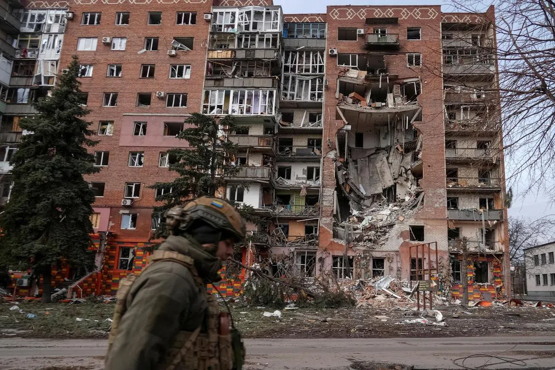 A Ukrainian serviceman passes by a residential building damaged by Russian military strikes, in the front-line town of Pokrovsk, in Ukraine's Donetsk region, on March 6.
