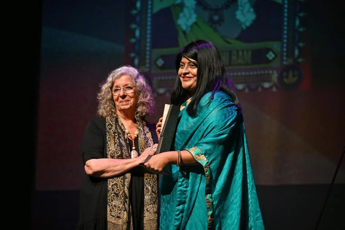 Prasanthi Ram receiving her award from Meira Chand at the Singapore Literature Prize ceremony in 2024.