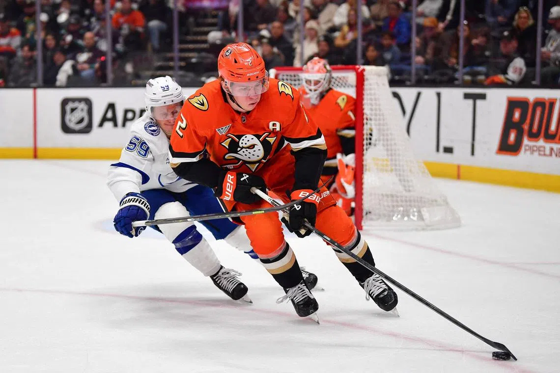 FILE PHOTO: Dec 31, 2025; Anaheim, California, USA; Anaheim Ducks defenseman Jackson Lacombe (2) moves the puck against Tampa Bay Lightning center Jake Guentzel (59) during the first period at Honda Center. Mandatory Credit: Gary A. Vasquez-Imagn Images/File Photo