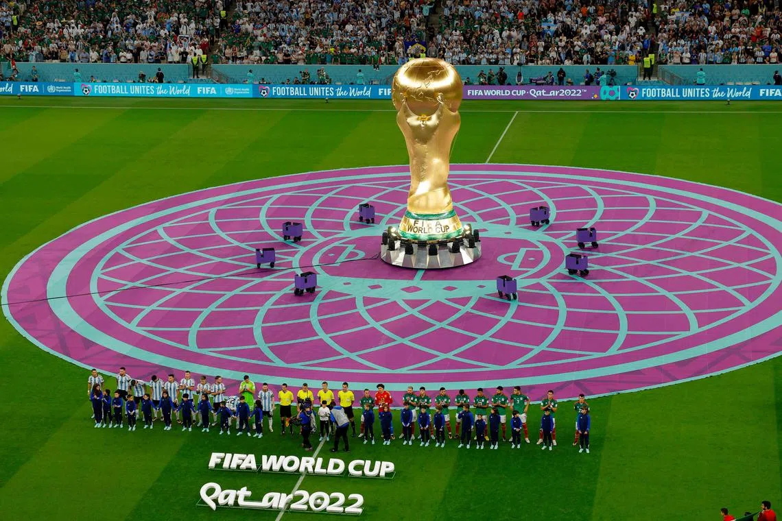 Teams lining up in front of the large-scale World Cup trophy replica ahead of the World Cup Group C football match between Argentina and Mexico at the Lusail Stadium on Nov 26. 