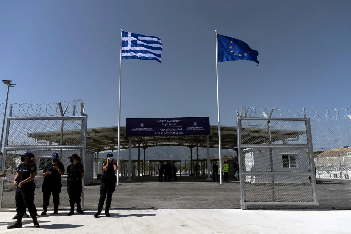 FILE PHOTO: A Greek national flag and a European Union flag flutter inside a newly inaugurated closed-type migrant camp on the island of Samos, Greece, September 18, 2021.  REUTERS/Alkis Konstantinidis/File Photo