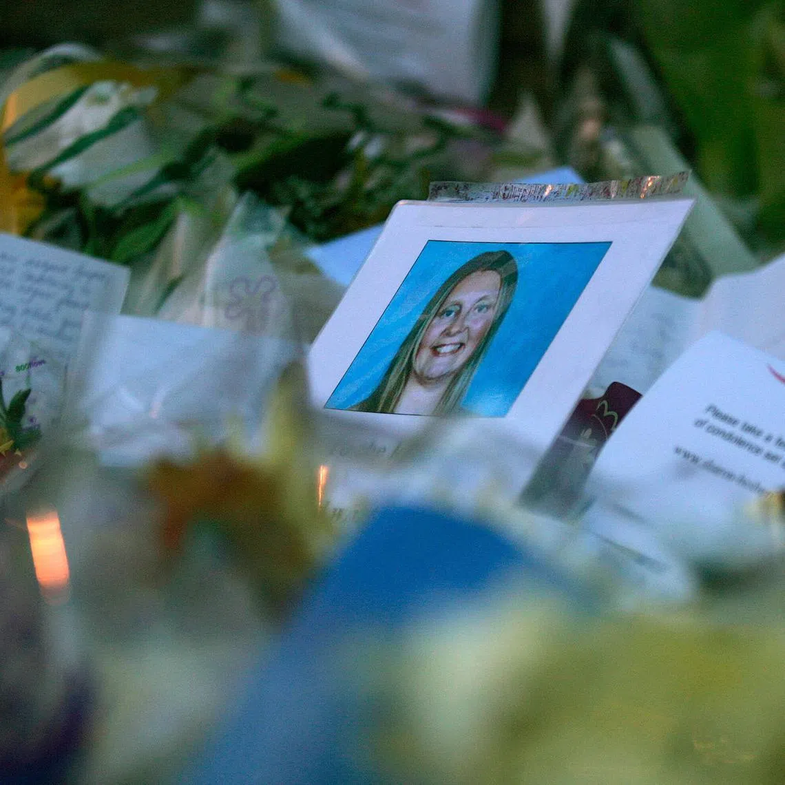 FILE PHOTO: A photograph of murdered Sharon Beshenivsky is seen among the floral tributes left by well-wishers in Bradford November 20, 2005.  REUTERS/Russell Boyce/ File photo