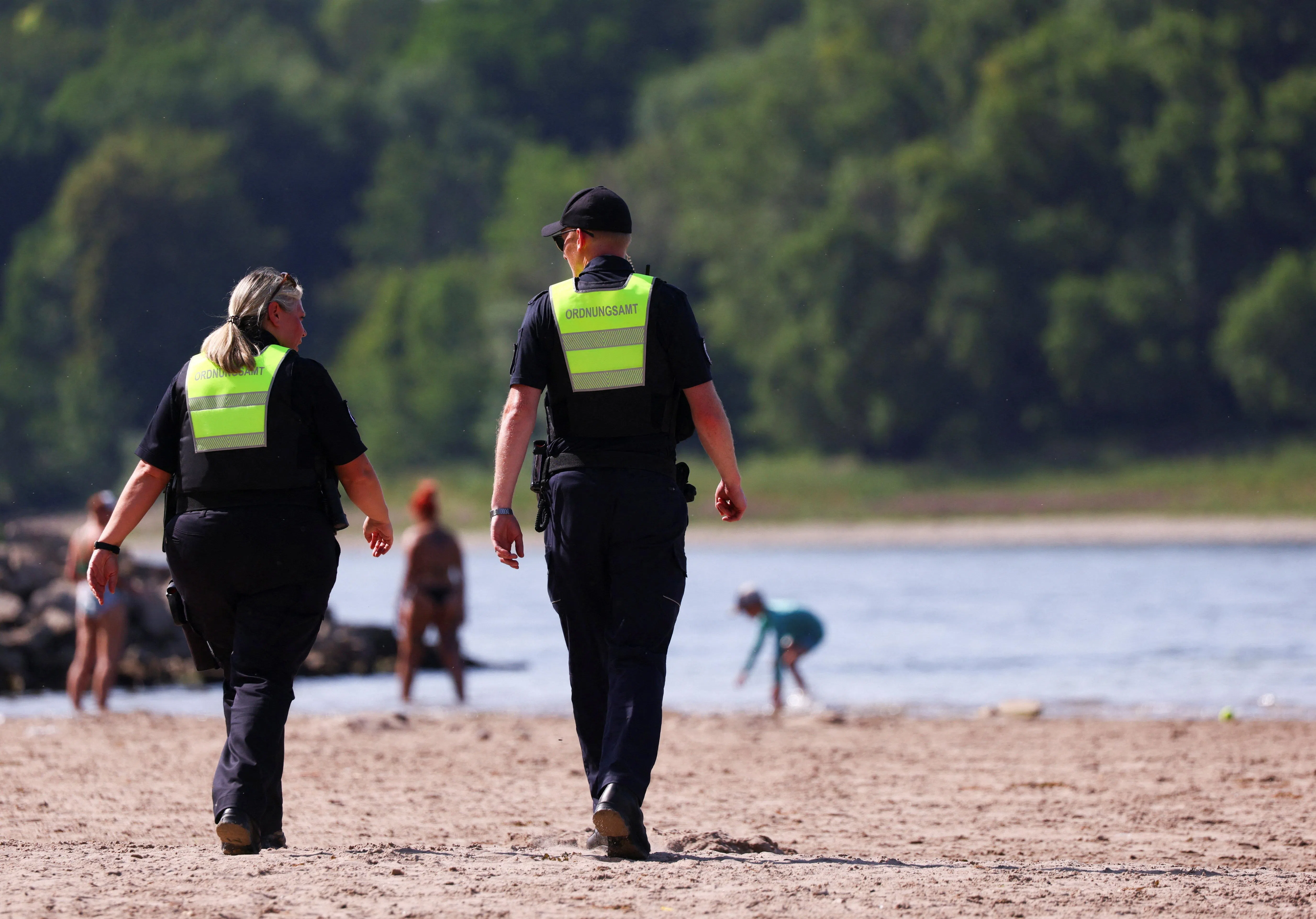 Members of the public order office patrol on the banks of the Rhine River, amid a heatwave in Cologne, Germany, June 24, 2026. Swimming in the Rhine River is prohibited by local authorities. REUTERS/Thilo Schmuelgen