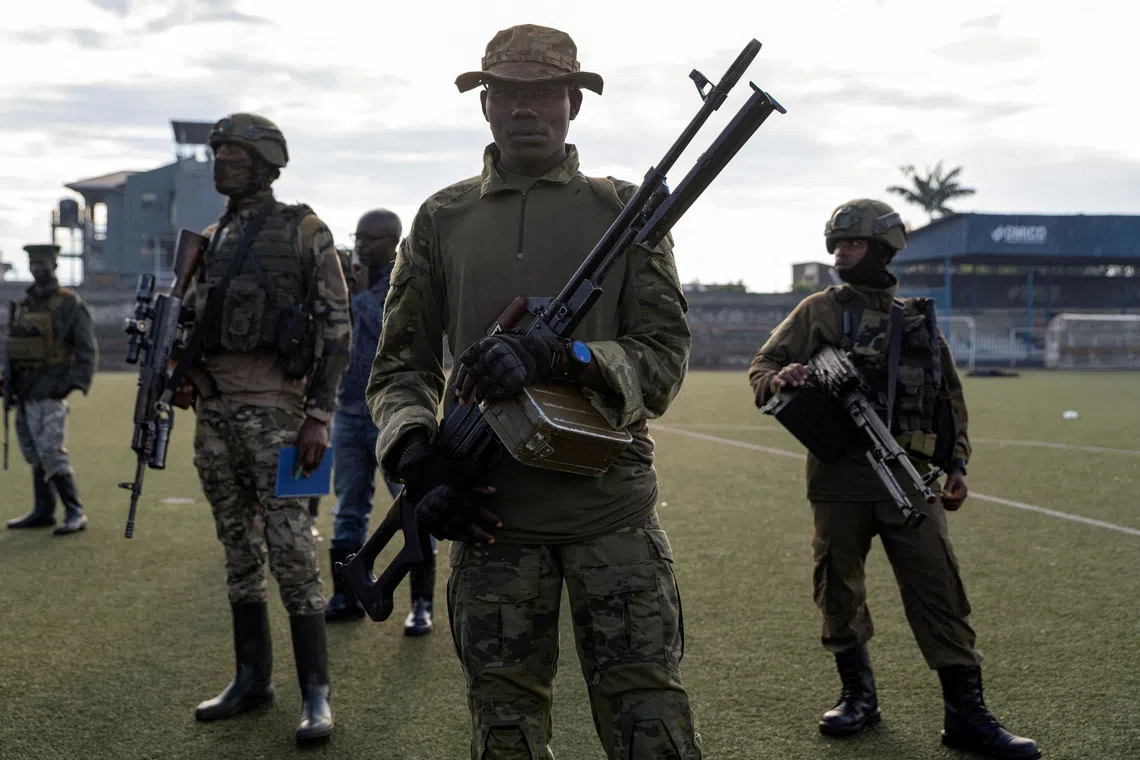 FILE PHOTO: M23 rebels stand guard at the the Unite stadium, where captured members of the armed forces of the Democratic Republic of the Congo (FARDC) and Wazalendo troops wait to be taken aboard trucks for training by M23 rebels, in Goma, North Kivu, Democratic Republic of Congo, May 10, 2025. REUTERS/Arlette Bashizi/File Photo