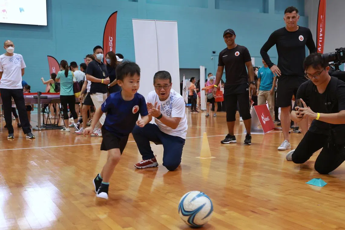 Minister for Culture, Community and Youth Edwin Tong (in white) cheers on four-year-old Zeph Chang at the FunFam Sportfest 2022.