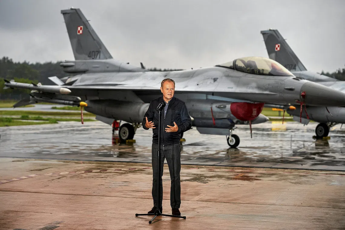 Polish Prime Minister Donald Tusk stands in front of Polish Air Force F-16 fighter jets as he holds a press conference regarding the threat posed by Russian drones in Polish airspace at the 32nd Tactical Air Base in Lask, about 30 km south-west of Lodz, Poland, September 11, 2025. Agencja Wyborcza.pl/Tomasz Stanczak via REUTERS