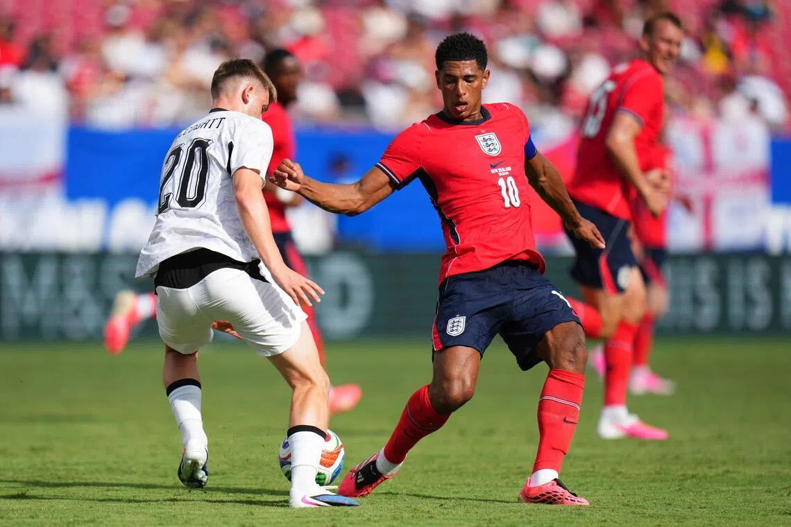 England's Jude Bellingham (right) tackles Callum McCowatt of New Zealand during the international friendly match between England and New Zealand at Raymond James Stadium on June 06 in Tampa, Florida.   