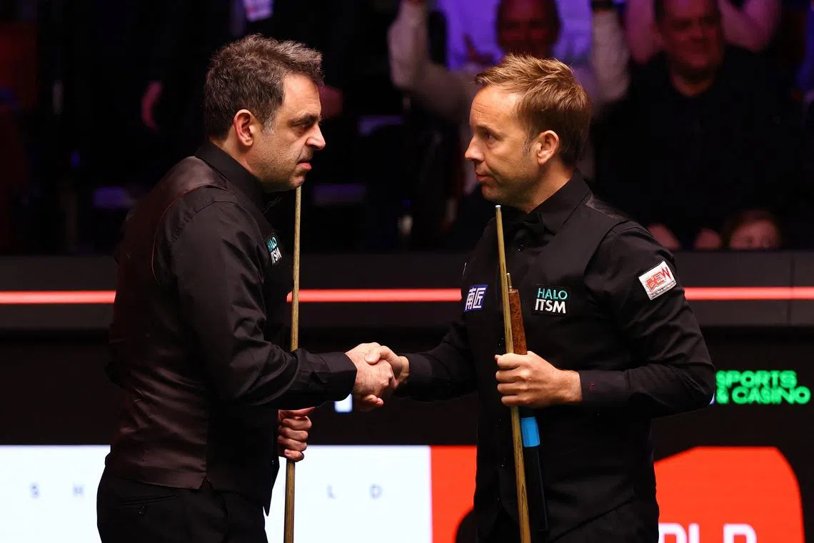 England's Ronnie O'Sullivan shaking hands with compatriot Ali Carter on April 23, after winning their first-round match.
