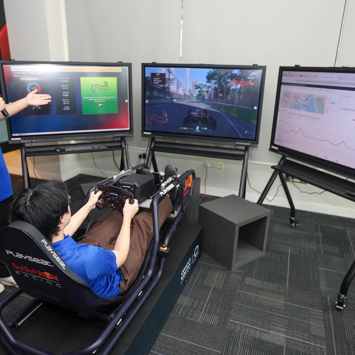 Temasek Polytechnic Big Data and Analytics second-year student Billy Lim Xiao Xi (right), alongside his course mate Khant Thu John, demonstrating the use of the simulator at the school’s DRIVE lab on Oct 6.