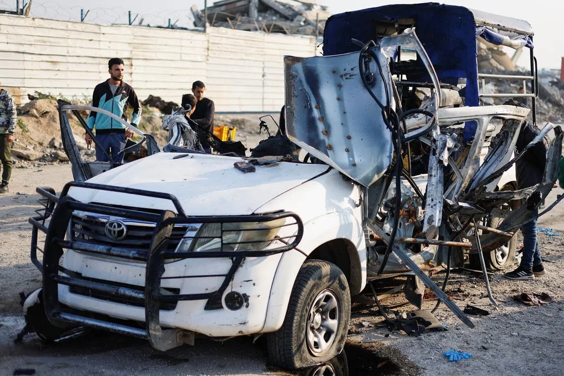 Palestinians inspect the site of an Israeli airstrike targeting a police vehicle in the central Gaza Strip, March 15, 2026. REUTERS/Mahmoud Issa