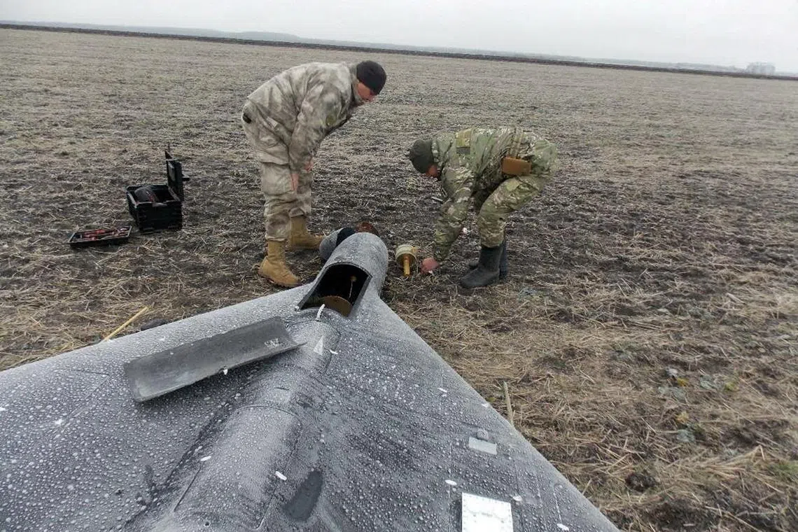 FILE PHOTO: Members of police demining unit remove a warhead from a Russian kamikaze unmanned aerial vehicle landed by a radio electronic warfare during one of latest drone strikes, amid Russia's attack on Ukraine, in an unknown location in Ukraine, in this handout picture released January 26, 2024.  Press service of the National Police of Ukraine/Handout via REUTERS/File Photo