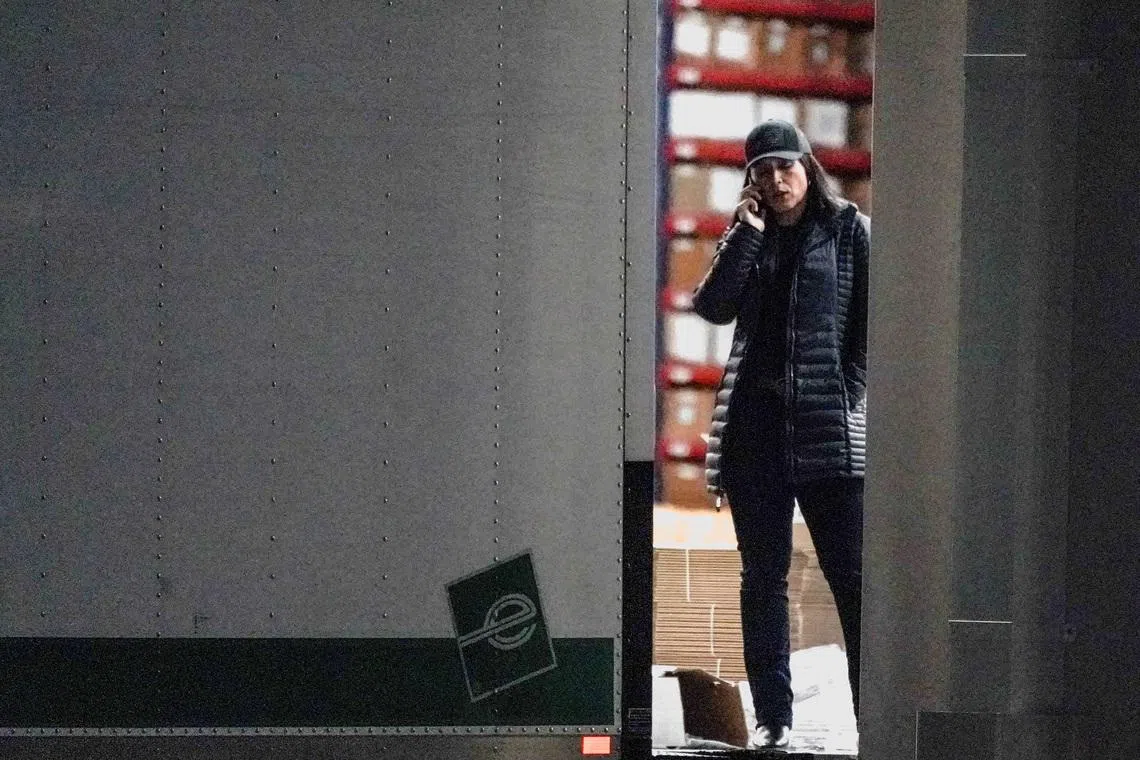 FILE PHOTO: U.S. Director of National Intelligence Tulsi Gabbard speaks on the phone while standing at the edge of a truck loading bay after the FBI executed a search warrant for the Fulton County Election Hub and Operation Center in relation to the 2020 election, according to a law enforcement official familiar with the matter, in Union City, Georgia, U.S. January 28, 2026.  REUTERS/Elijah Nouvelage./File Photo
