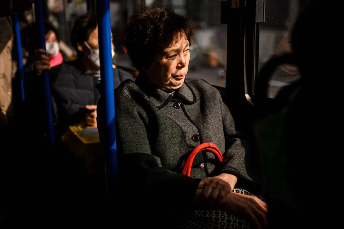 Commuters travel on a bus in Seoul on February 14, 2024. (Photo by ANTHONY WALLACE / AFP)