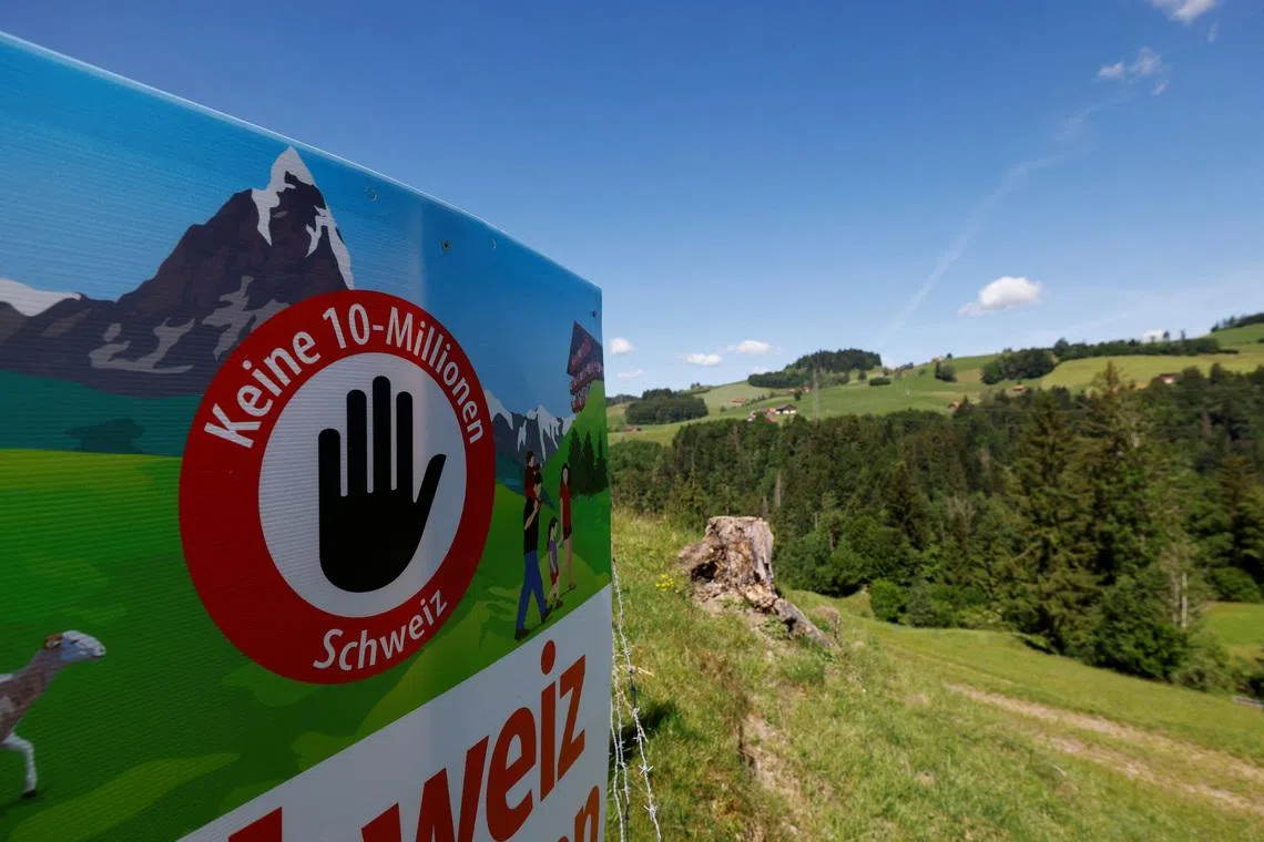 A sign sits in a field, on the day of the vote on a plan backed by the right-wing Swiss People's Party (SVP) to limit population growth to 10 million inhabitants, near Hundwil, Switzerland, June 14, 2026.  REUTERS/Michaela Stache