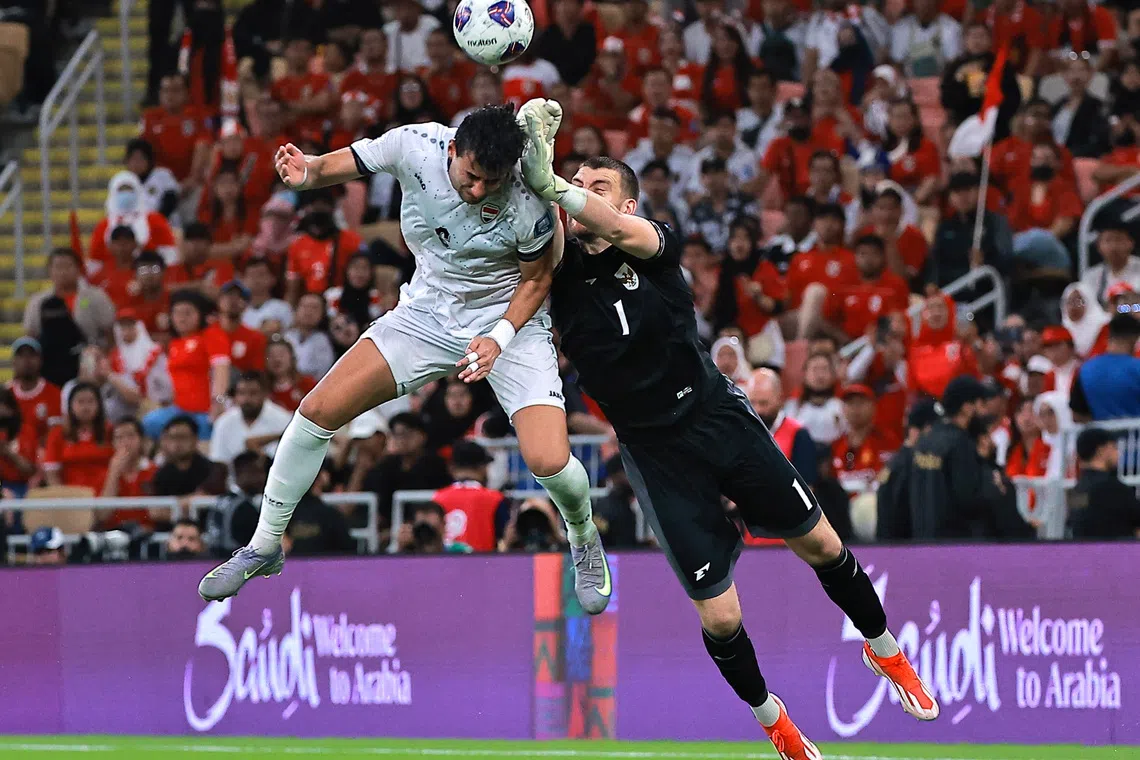 Soccer Football - FIFA World Cup - AFC Qualifiers - Group B - Iraq v Indonesia - King Abdullah Sport City, Jeddah, Saudi Arabia - October 11, 2025 Indonesia's Maarten Paes in action with Iraq's Munaf Younus REUTERS/Stringer