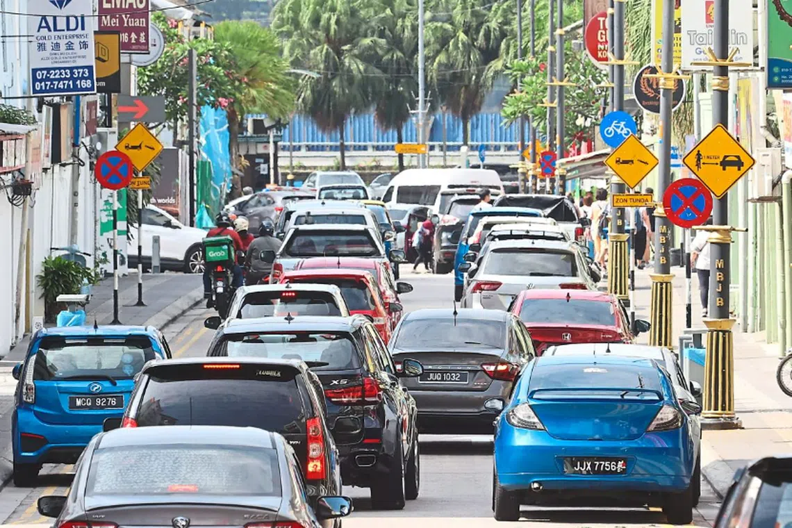 Cars and a motorcycle parked illegally along a walkway in Jalan Dhoby in downtown Johor Bahru.