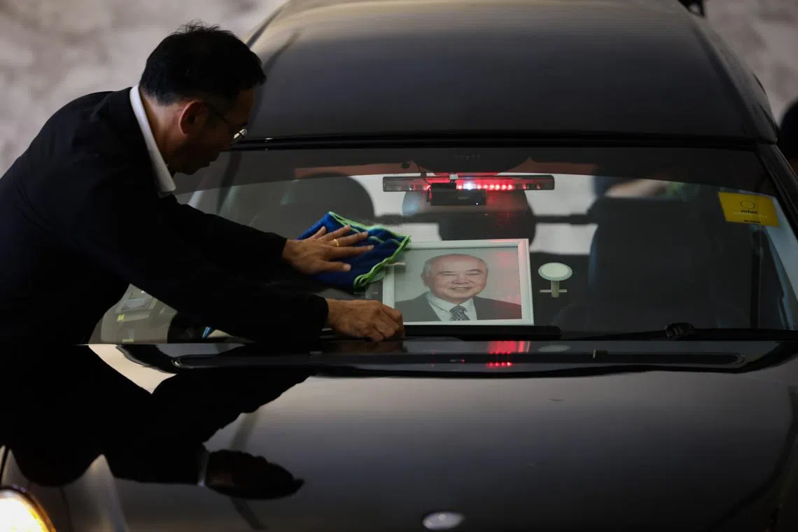 Staff wiping the windshield of the hearse while waiting the arrival of the coffin at Woodlands Memorial on Feb 7, 2024.